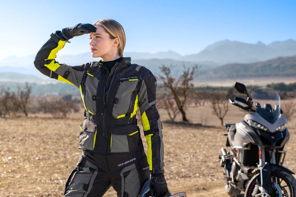 a. woman standing by her motorcycle wearing black fluo motorcycle lady jacket