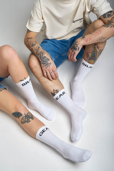 Woman's and man's legs wearing white socks with "break" and "gear"