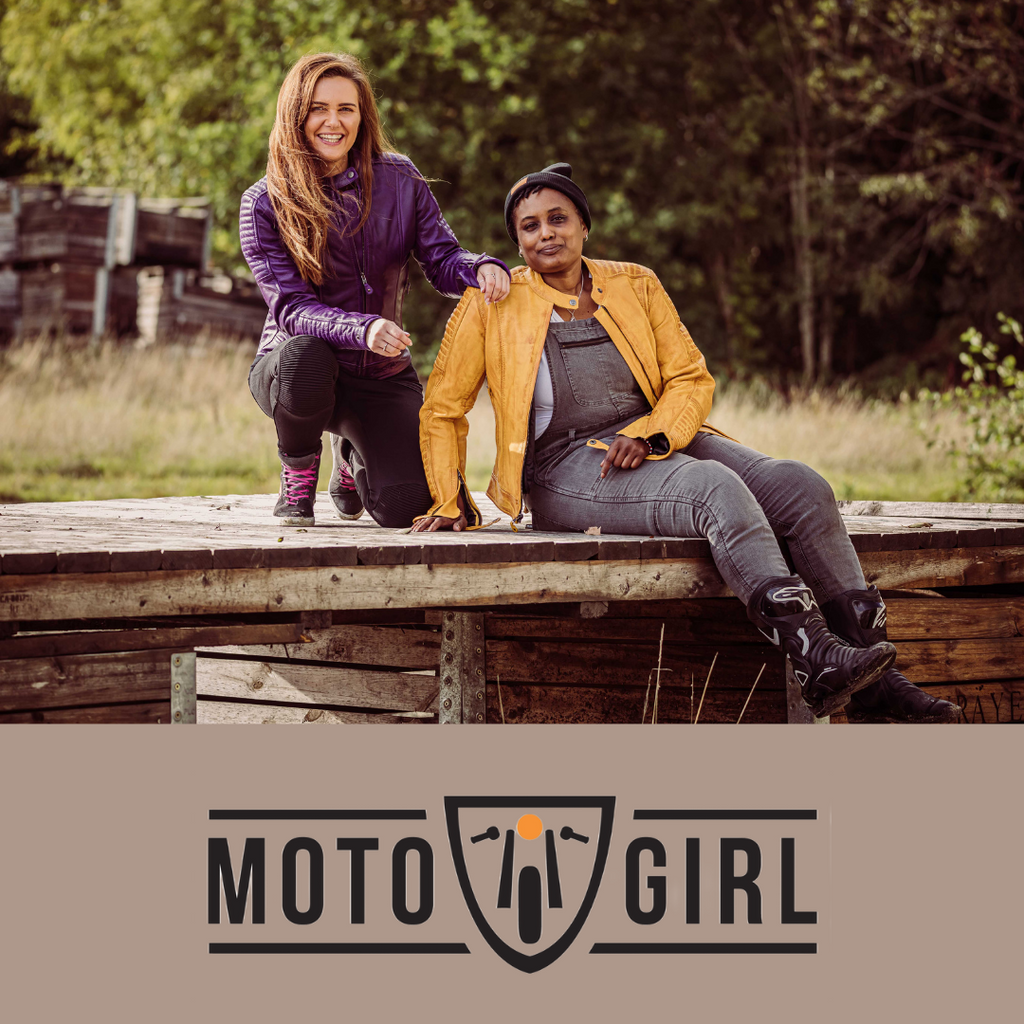 Two women wearing colourful female motorcycle jackets from MotoGirl sitting on the bridge