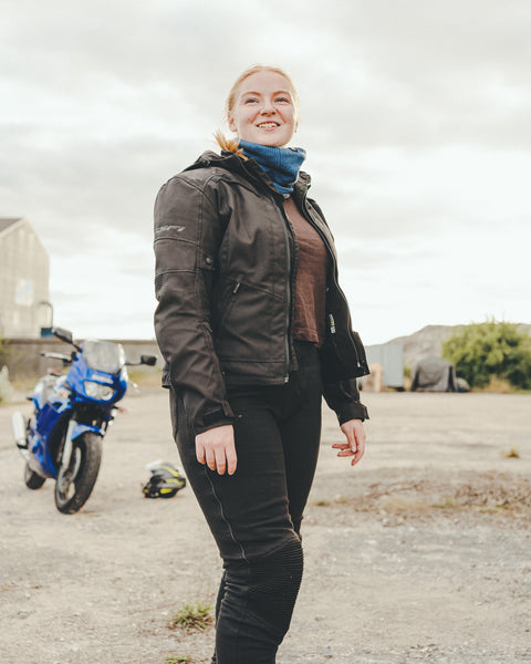 A young woman wearing black motorcycle jacket 