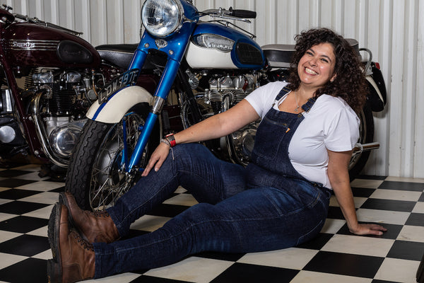 A woman siting by the motorcycle wearing Blue kevlar motorcycle overall for women from Motogirl