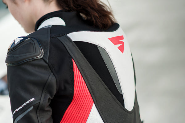 A close up of a woman's back wearing Women's racing suit MIURA RS in black, white and fluo from Shima 