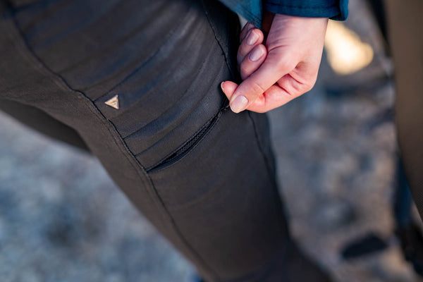 woman's hand zipping a pocket on lady motorcycle trousers