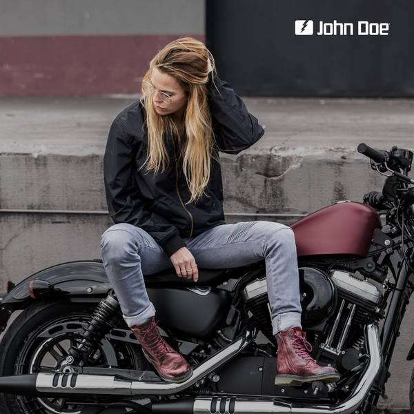 A young woman on a motorcycle wearing red women's motorcycle boots