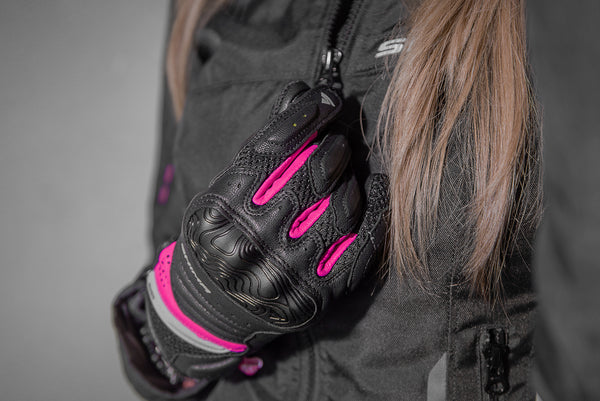 A close up of a woman's hand wearing Black and pink women's motorcycle gloves Rush lady  from Shima